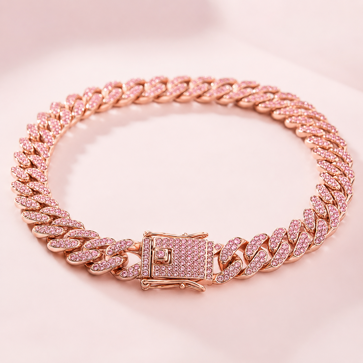 Rose gold chain bracelet with pink gemstones on a pink background